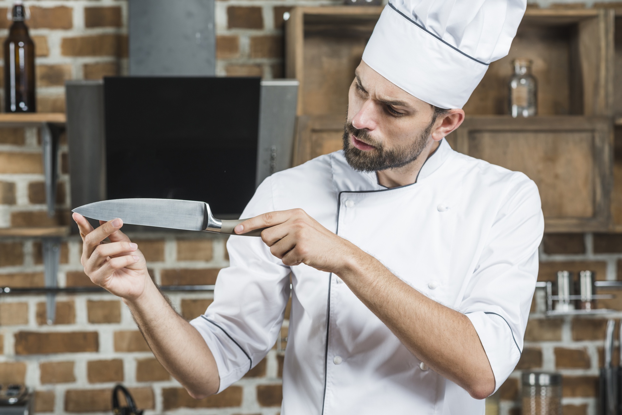 Chef demonstrating a knife skill in a modern kitchen